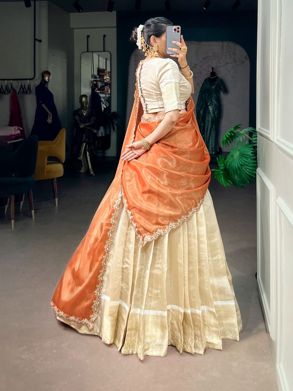 Golden and red half saree lehenga by Laksharaa Sarees, featuring intricate embroidery and flowing fabric in a vibrant design.
