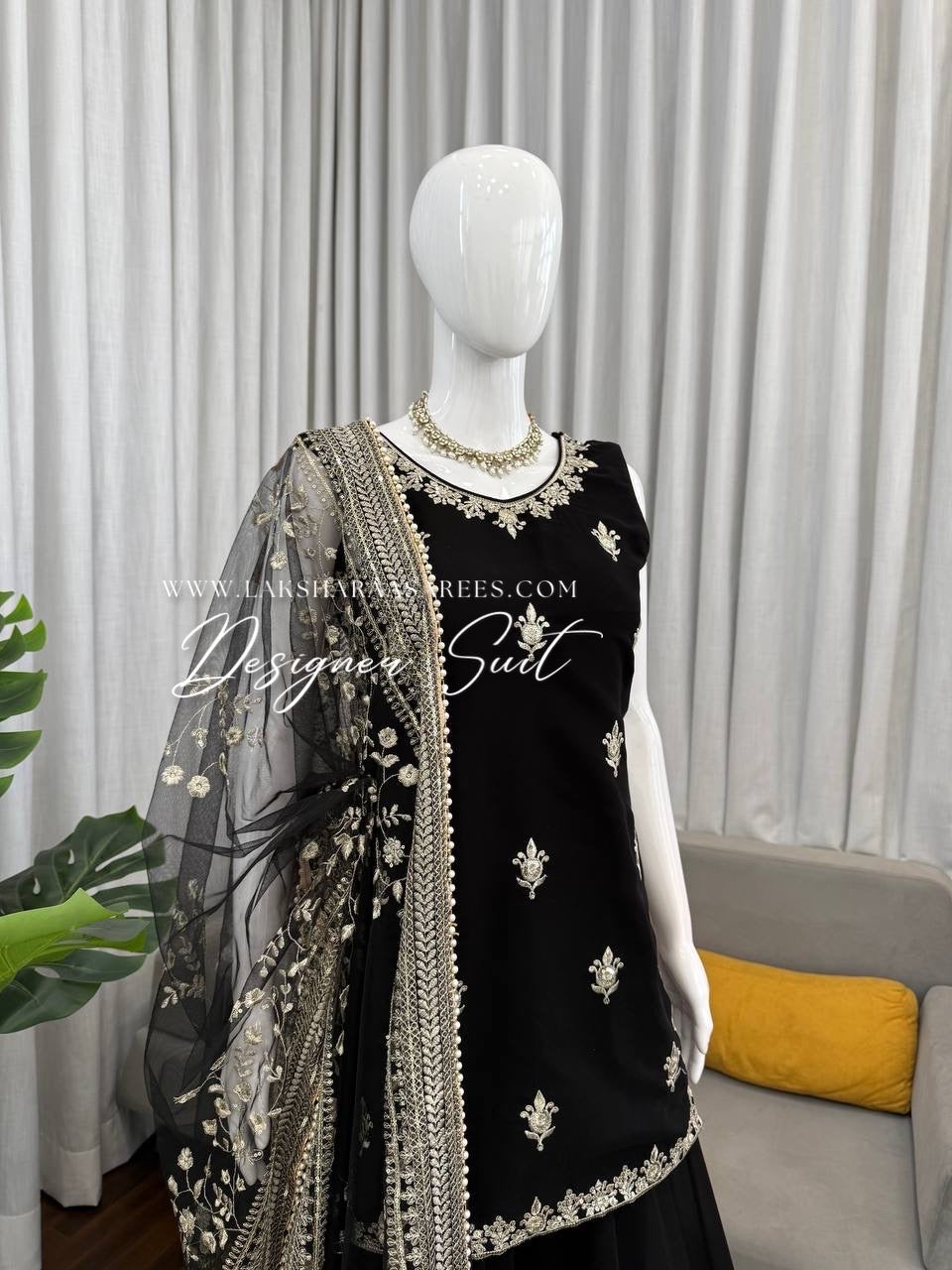 Black georgette palazzo suit by Laksharaa Sarees, featuring a flowy top and wide-leg pants with elegant draping.