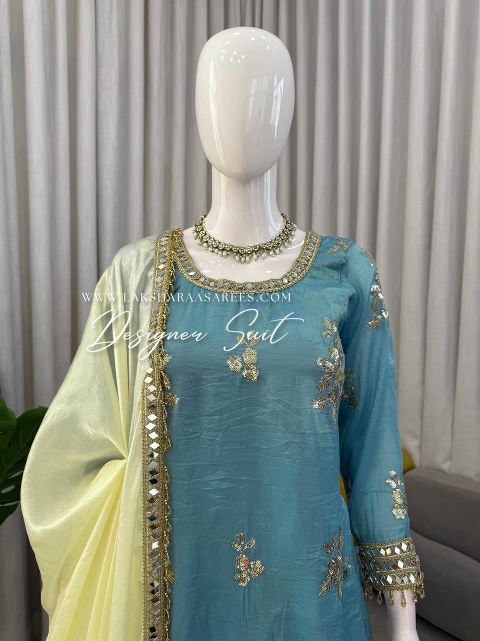 Blue and yellow shimmer silk designer suit from Laksharaa Sarees featuring intricate embroidery and elegant traditional style.