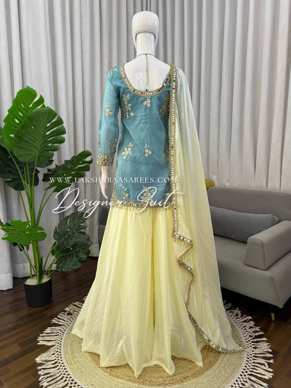 Blue and yellow shimmer silk designer suit from Laksharaa Sarees, featuring intricate jasmine-inspired embroidery and elegant craftsmanship.