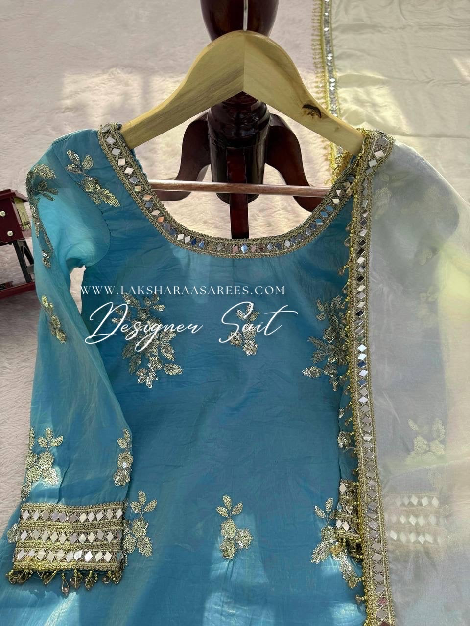 Blue and yellow shimmer silk designer suit with intricate patterns from Laksharaa Sarees, featuring elegant traditional styling.