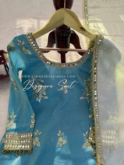 Blue and yellow shimmer silk designer suit with intricate patterns from Laksharaa Sarees, featuring elegant traditional styling.