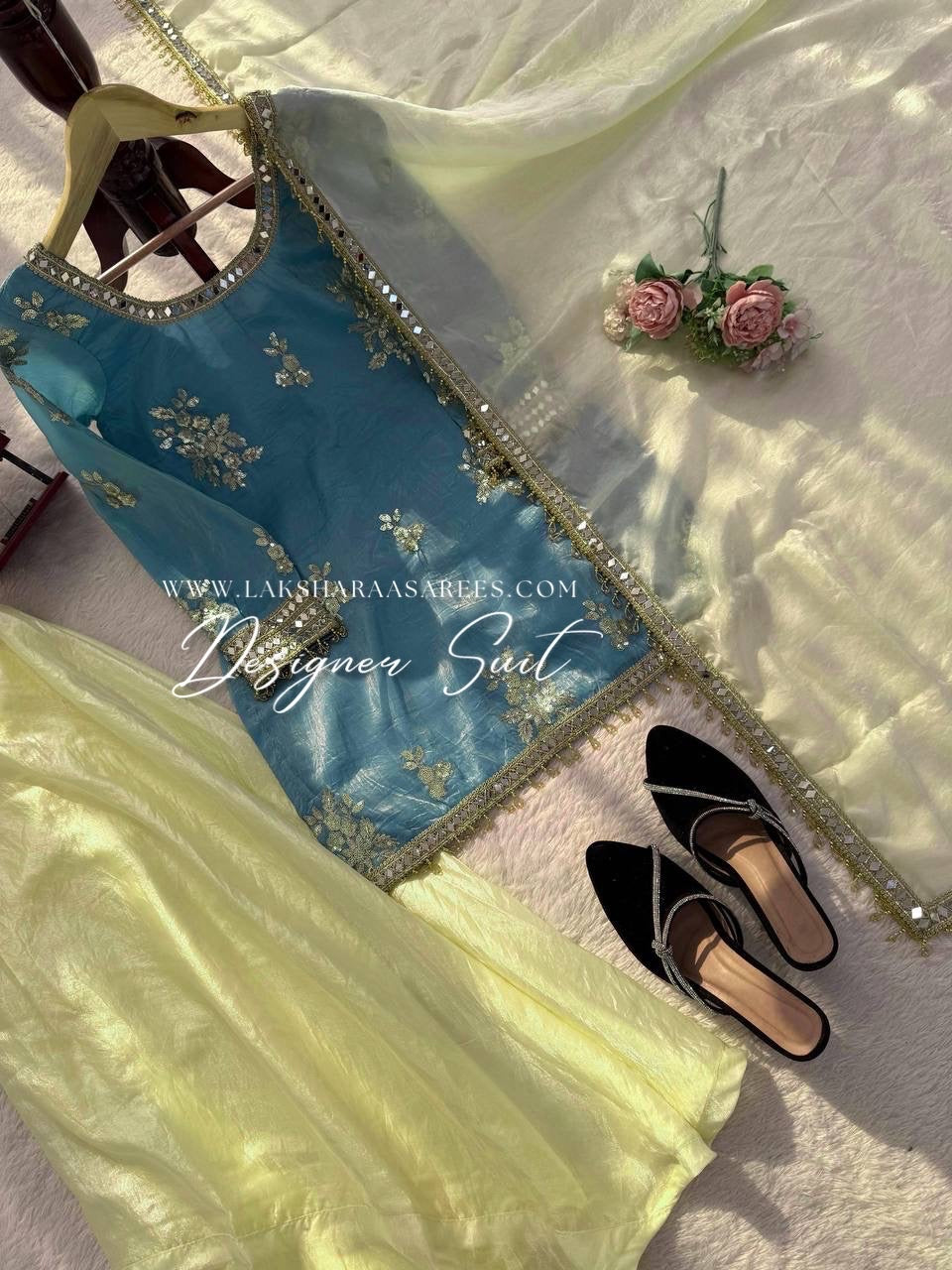 Blue and yellow shimmer silk designer suit from Laksharaa Sarees featuring intricate jasmine embroidery and elegant traditional styling.