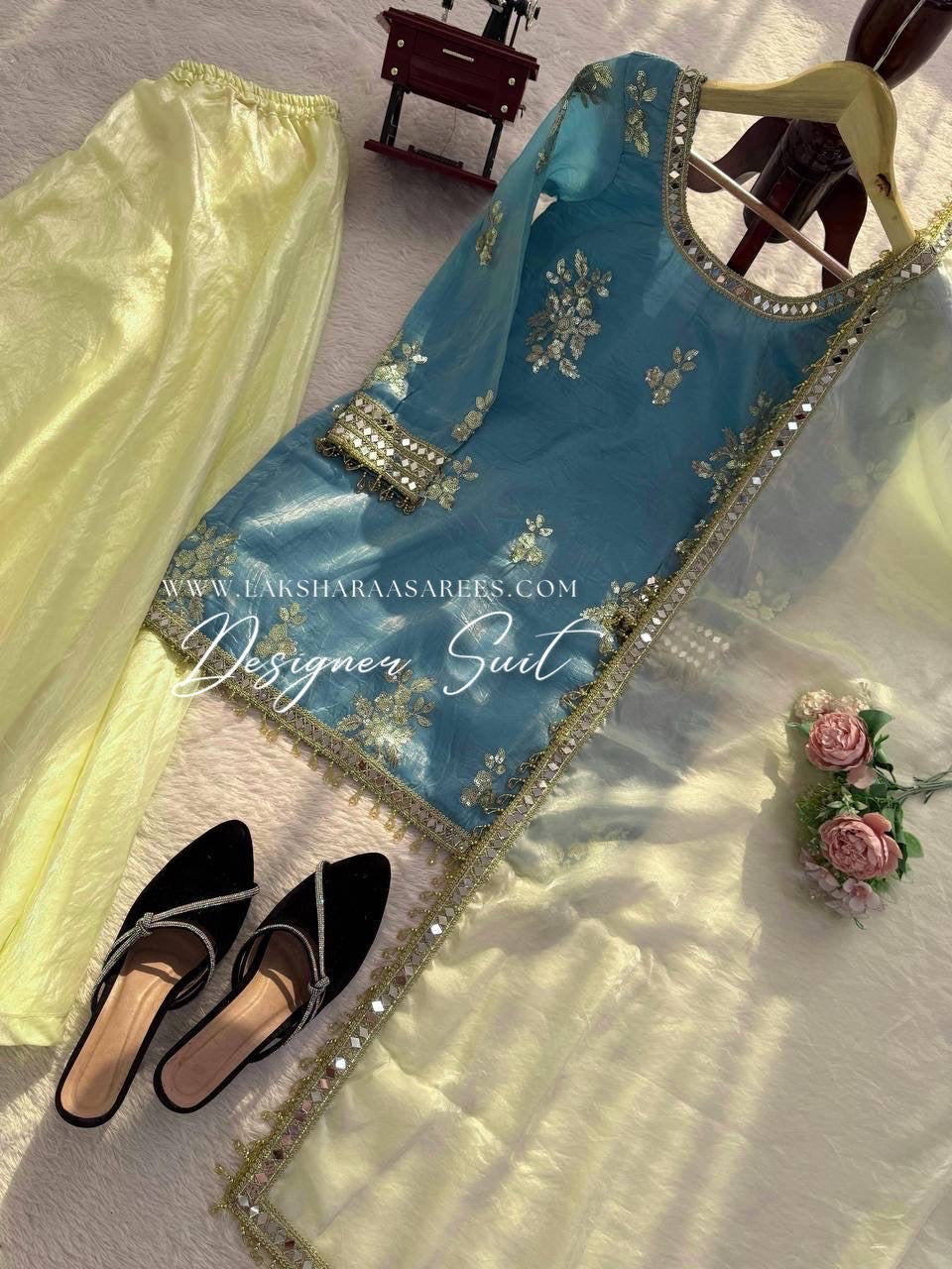 Blue and yellow shimmer silk designer suit with intricate patterns, featuring the JASMINE Laksharaa Sarees brand label.