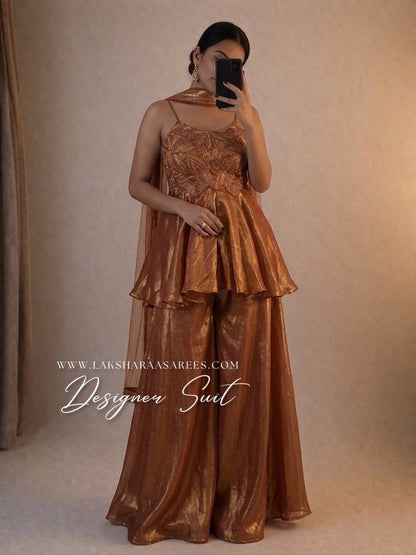 Peachy gold designer suit by Laksharaa Sarees, featuring intricate embroidery and traditional craftsmanship.