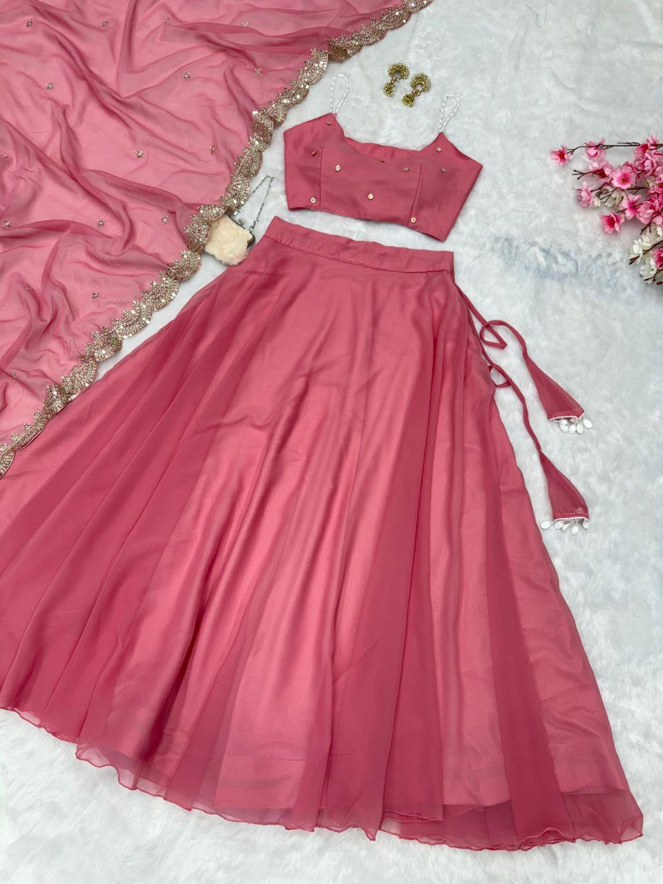 Beaded strap blouse paired with a ready-made lehenga in vibrant colors, featuring intricate embroidery and embellishments.